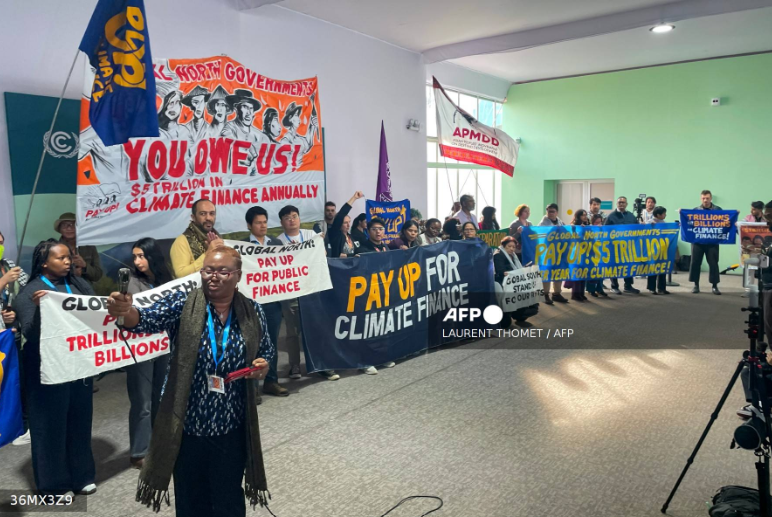 Activists with banners and flags hold a gathering to demand that rich countries help developing nations tackle global warming, during the UN Climate Change Conference (COP29) in Baku, Azerbaijan, on November 21, 2024. (Photo by Laurent THOMET / AFP) Related c