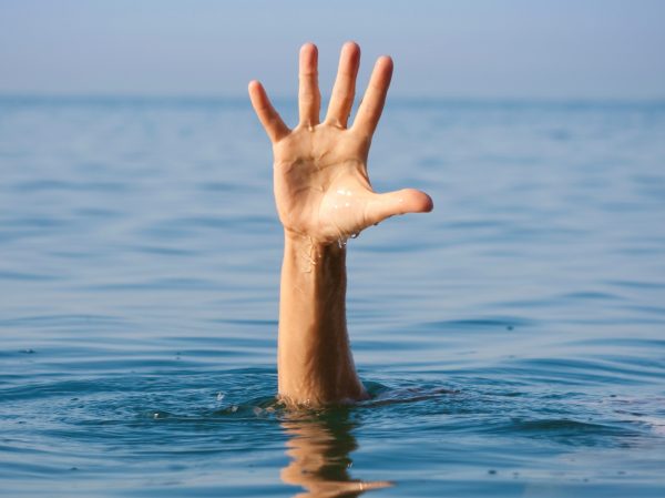 single hand of drowning man in sea asking for help