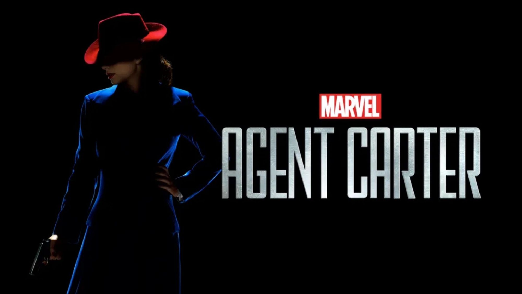 Agent Carter holding a gun, standing in the shadows.