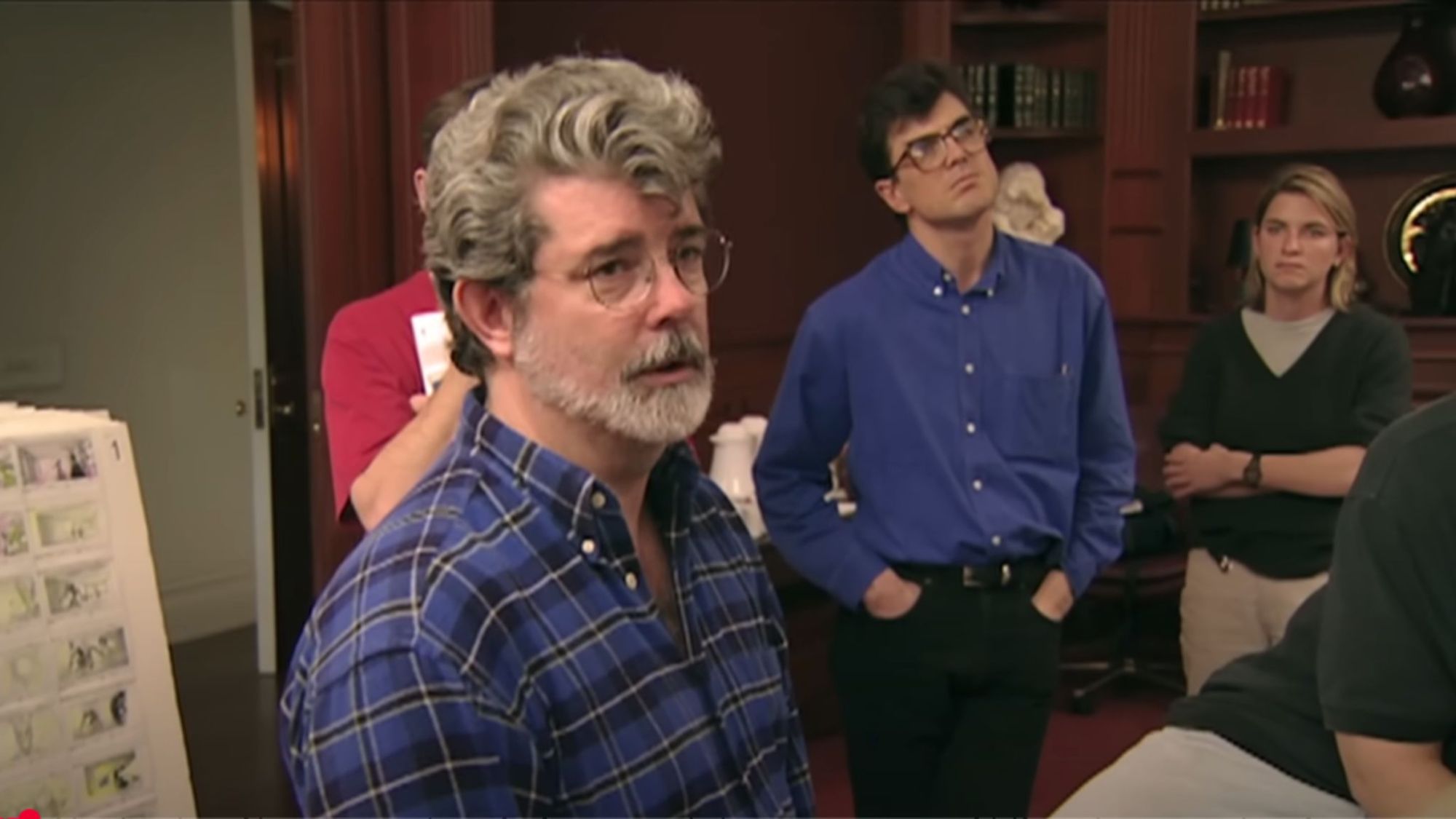 George Lucas standing in a room surrounded by film production team.