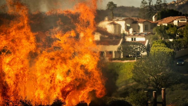 Thousands flee as wildfire whips through L.A. hillsides