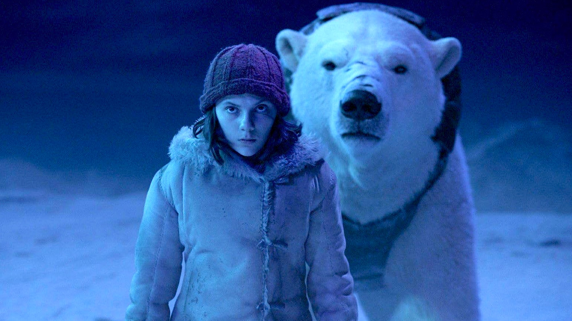 Dafne Keen with polar bear behind her in His Dark Materials