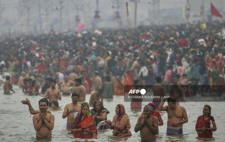 Hindu pilgrims take a dip in the sacred waters of Sangam, the confluence of Ganges, Yamuna and mythical Saraswati rivers during the Maha Kumbh Mela festival in Prayagraj on January 13, 2025